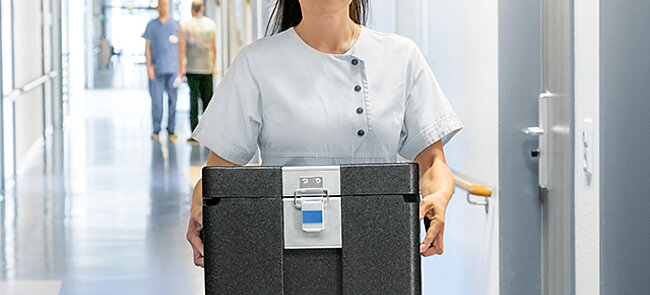 Une femme portant une boîte isolante noire