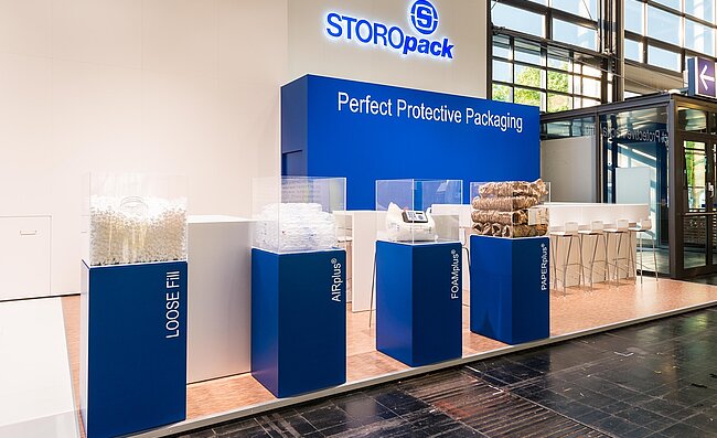 Un stand de salon Storopack avec quatre vitrines bleues