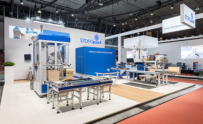 Un stand de salon Storopack avec quatre vitrines bleues