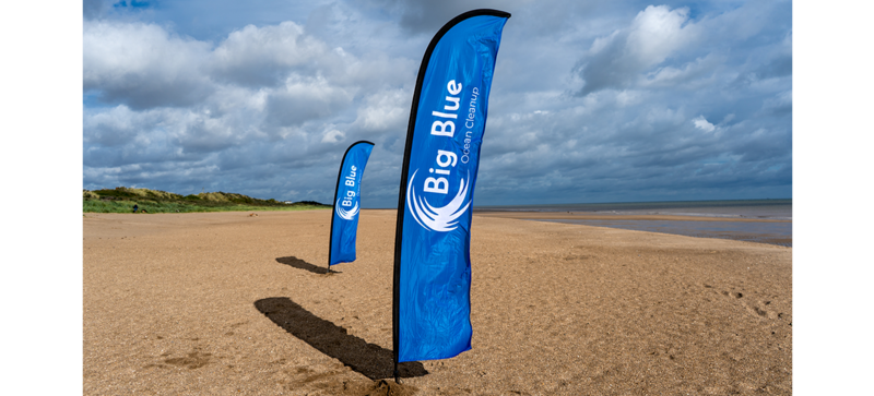 Deux drapeaux de l’organisation Big Blue Ocean Cleanup sur la plage