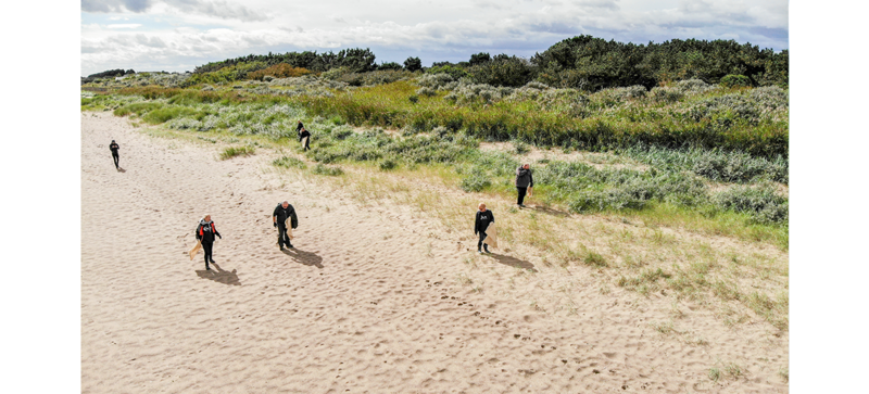 Plusieurs personnes qui nettoient sur la plage