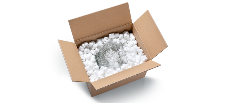 Un carton contenant un vase en verre et des chips d’emballage blanches en forme de S