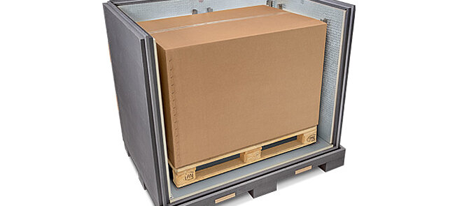 Un conteneur isolant gris avec un carton intérieur et des blocs réfrigérants sur une palette