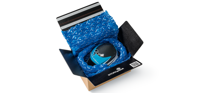 Un carton contenant un casque et des coussins d’air bleus
