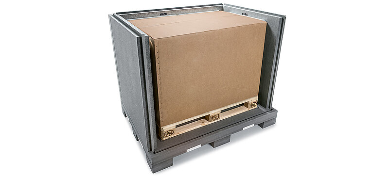 Un conteneur isolant noir avec un carton intérieur et des blocs réfrigérants sur une palette 