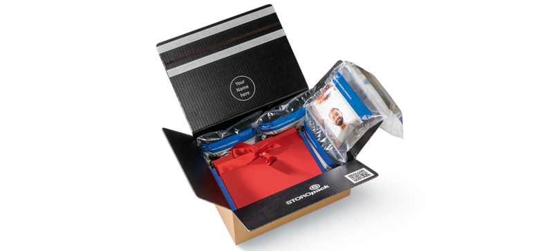 Un carton contenant une boîte-cadeau rouge et des coussins d’air avec motif imprimé